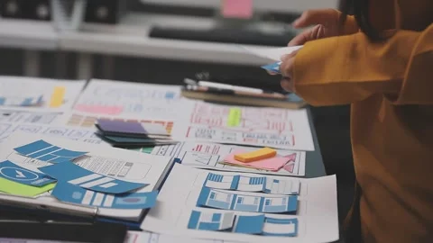 Group of young application developers analyzing uxui mobile app templates d.. Stock Footage 320526545