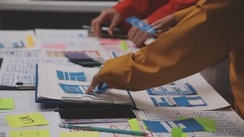 Group of young application developers analyzing uxui mobile app templates d.. Stock Footage 320526552