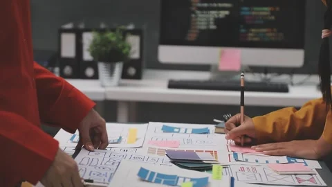 Group of young application developers analyzing uxui mobile app templates d.. Stock Footage 320526595