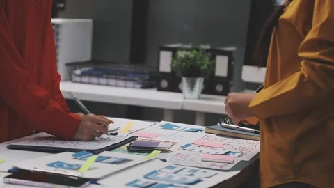 Group of young application developers analyzing uxui mobile app templates d.. Stock Footage 320526604