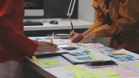 Group of young application developers analyzing uxui mobile app templates d.. Stock Footage 320526618