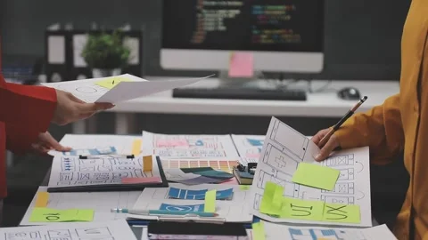 Group of young application developers analyzing uxui mobile app templates d.. Stock Footage 320526654