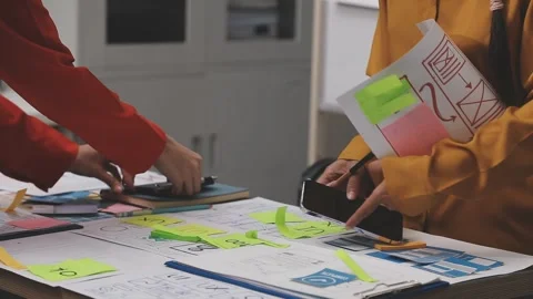 Group of young application developers analyzing uxui mobile app templates d.. Stock Footage 320526658