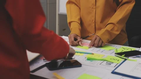 Group of young application developers analyzing uxui mobile app templates d.. Stock Footage 320526666