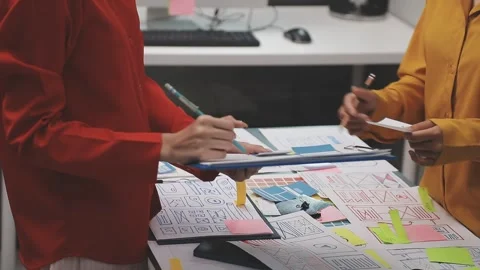 Group of young application developers analyzing uxui mobile app templates d.. Stock Footage 320526673
