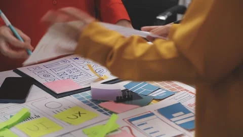 Group of young application developers analyzing uxui mobile app templates d.. Stock Footage 320526682