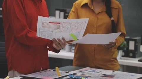 Group of young application developers analyzing uxui mobile app templates d.. Stock Footage 320526700