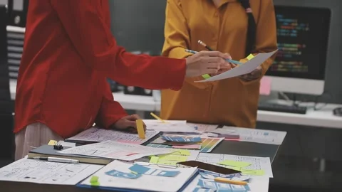Group of young application developers analyzing uxui mobile app templates d.. Stock Footage 320526703