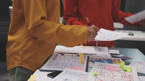 Group of young application developers analyzing uxui mobile app templates d.. Stock Footage 320526710