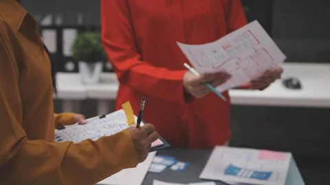 Group of young application developers analyzing uxui mobile app templates d.. Stock Footage 320526779