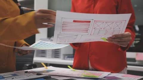 Group of young application developers analyzing uxui mobile app templates d.. Stock Footage 320526991