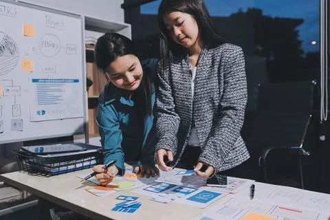 Group of young application developers analyzing uxui mobile app templates d.. Stock Photos