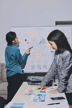 Group of young application developers analyzing uxui mobile app templates d.. Stock Photos