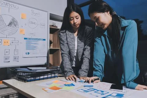 Group of young application developers analyzing uxui mobile app templates d.. Stock Photos