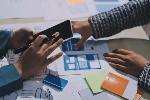 Group of young application developers analyzing uxui mobile app templates d.. Stock Photos