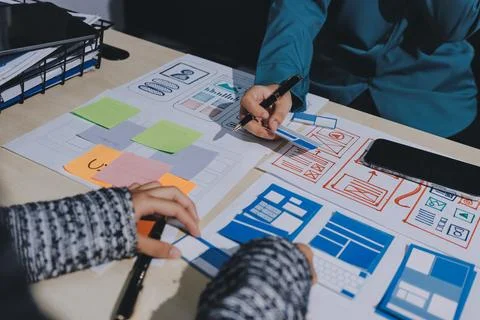 Group of young application developers analyzing uxui mobile app templates d.. Foto stock