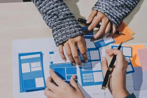 Group of young application developers analyzing uxui mobile app templates d.. Stock Photos