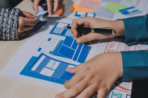 Group of young application developers analyzing uxui mobile app templates d.. Foto stock