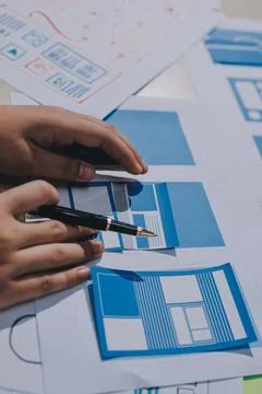 Group of young application developers analyzing uxui mobile app templates d.. Stock Photos