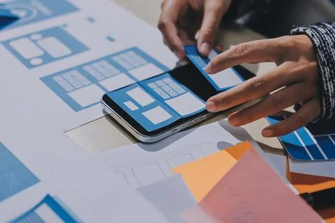 Group of young application developers analyzing uxui mobile app templates d.. Stock Photos