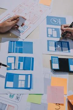 Group of young application developers analyzing uxui mobile app templates d.. Stock Photos