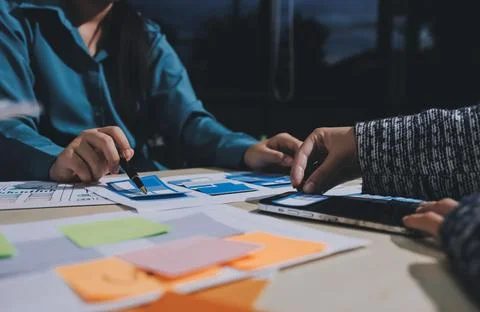 Group of young application developers analyzing uxui mobile app templates d.. Stock Photos