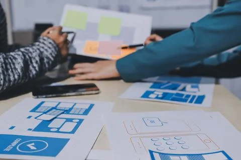 Group of young application developers analyzing uxui mobile app templates d.. Foto stock
