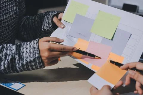 Group of young application developers analyzing uxui mobile app templates d.. Stock Photos