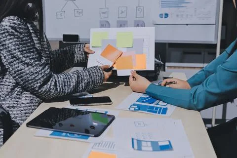 Group of young application developers analyzing uxui mobile app templates d.. Stock Photos