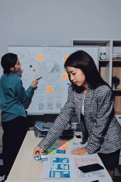 Group of young application developers analyzing uxui mobile app templates d.. Stock Photos