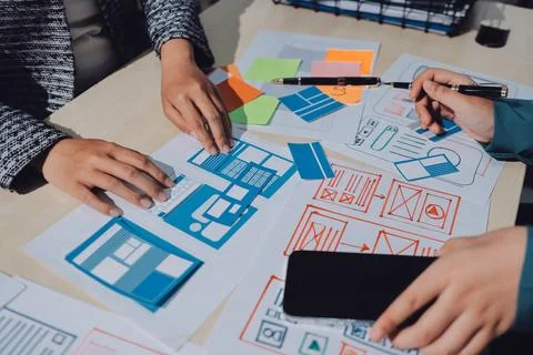 Group of young application developers analyzing uxui mobile app templates d.. Foto stock