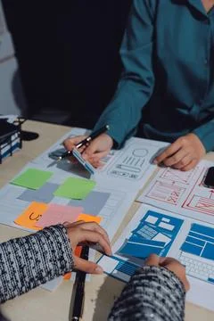 Group of young application developers analyzing uxui mobile app templates d.. Stock Photos