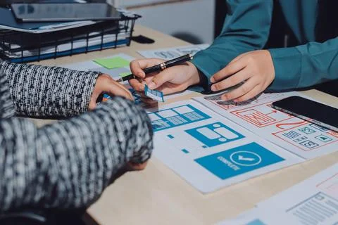 Group of young application developers analyzing uxui mobile app templates d.. Stock Photos