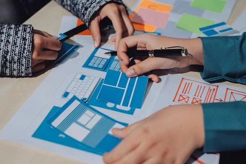 Group of young application developers analyzing uxui mobile app templates d.. Stock Photos