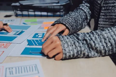 Group of young application developers analyzing uxui mobile app templates d.. Stock Photos