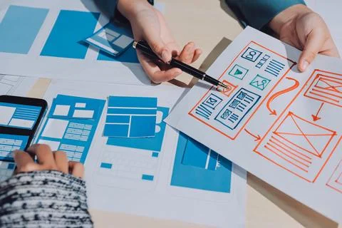 Group of young application developers analyzing uxui mobile app templates d.. Stock Photos