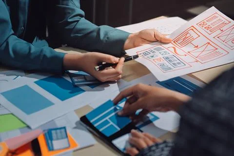 Group of young application developers analyzing uxui mobile app templates d.. Stock Photos