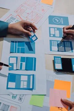 Group of young application developers analyzing uxui mobile app templates d.. Stock Photos