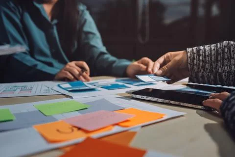 Group of young application developers analyzing uxui mobile app templates d.. Stock Photos