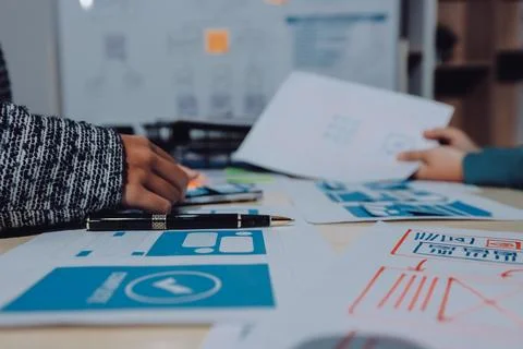 Group of young application developers analyzing uxui mobile app templates d.. Foto stock