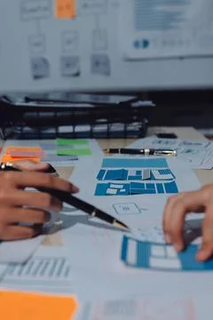 Group of young application developers analyzing uxui mobile app templates d.. Stock Photos