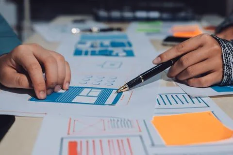 Group of young application developers analyzing uxui mobile app templates d.. Stock Photos
