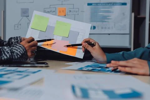 Group of young application developers analyzing uxui mobile app templates d.. Stock Photos