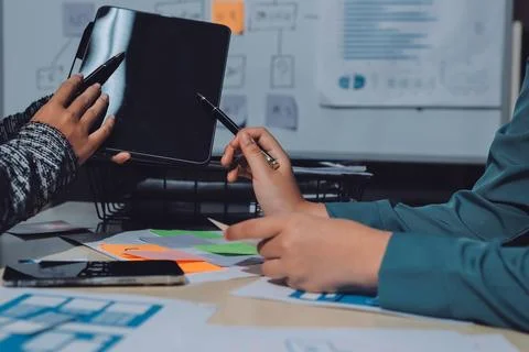 Group of young application developers analyzing uxui mobile app templates d.. Stock Photos