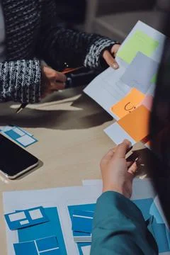Group of young application developers analyzing uxui mobile app templates d.. Stock Photos