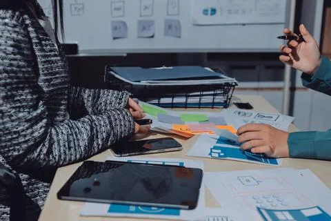 Group of young application developers analyzing uxui mobile app templates d.. Stock Photos