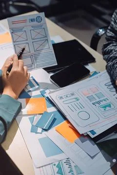 Group of young application developers analyzing uxui mobile app templates d.. Stock Photos