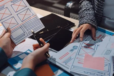 Group of young application developers analyzing uxui mobile app templates d.. Stock Photos