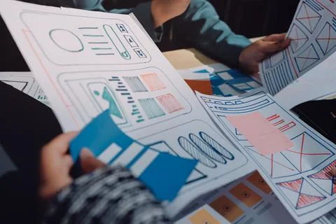Group of young application developers analyzing uxui mobile app templates d.. Foto stock