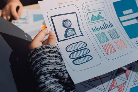 Group of young application developers analyzing uxui mobile app templates d.. Stock Photos